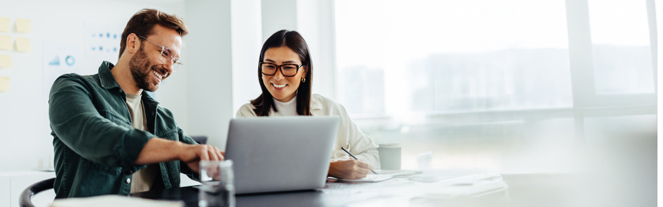 Menschen sitzen im Büro und schauen auf Laptop